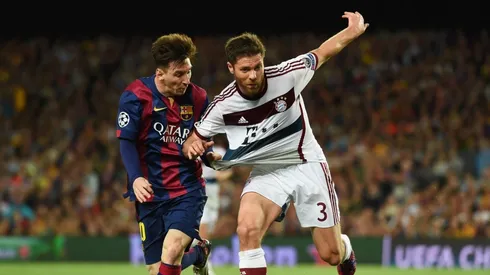 Xabi Alonso disputa el balón con Lionel Messi