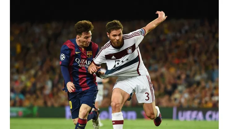 Xabi Alonso disputa el balón con Lionel Messi