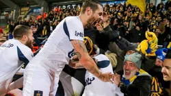 Hinchas y jugadores de Union Saint-Gilloise festejando juntos.