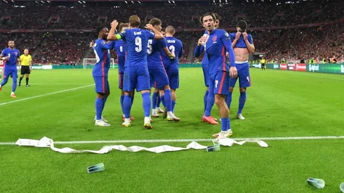 Jack Grealish tomando de un vaso que le arrojaron.