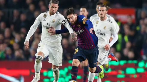 Sergio Ramos y lionel Messi disputan un balón en un Clásico.