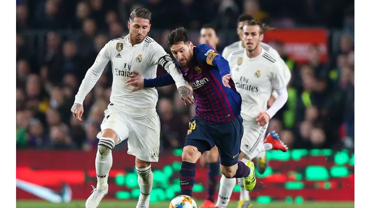Sergio Ramos y lionel Messi disputan un balón en un Clásico.