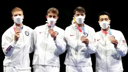 Race Imboden se dibujó una cruz en su mano para recibir una medalla.
