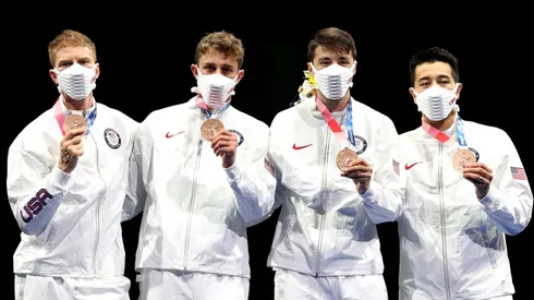 Race Imboden se dibujó una cruz en su mano para recibir una medalla.