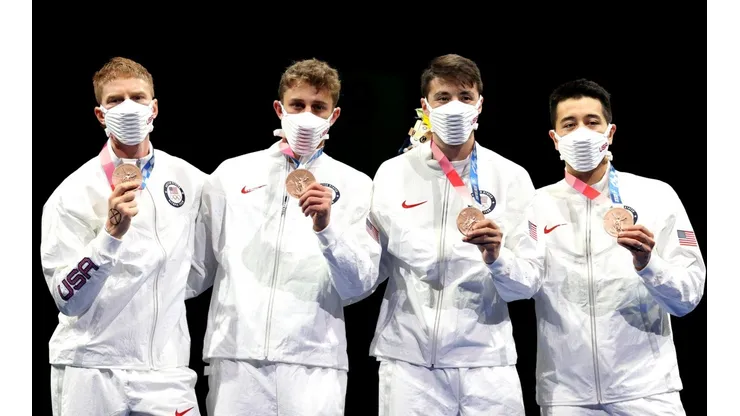 Race Imboden se dibujó una cruz en su mano para recibir una medalla.