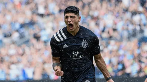 Alan Pulido festejando el gol bajo la lluvia.