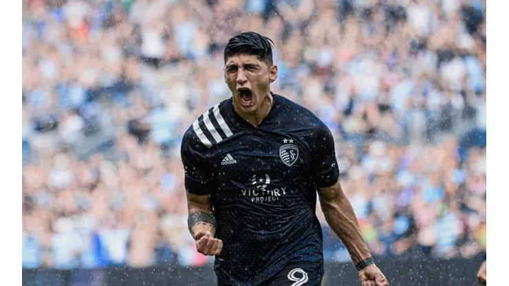 Alan Pulido festejando el gol bajo la lluvia.