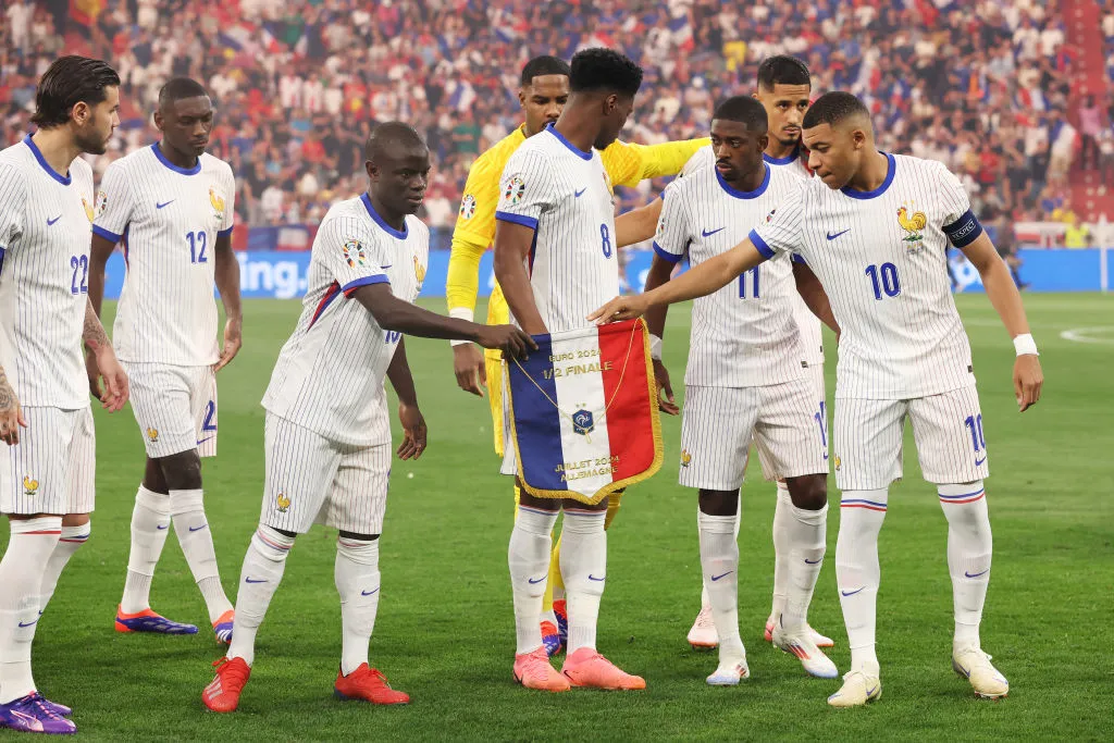 MUNICH, GERMANY – JULY 09: Kylian Mbappe of France hands the match pennant to teammate N’Golo Kante prior to the UEFA EURO 2024 Semi-Final match between Spain and France at Munich Football Arena on July 09, 2024 in Munich, Germany. (Photo by Alex Grimm/Getty Images)
