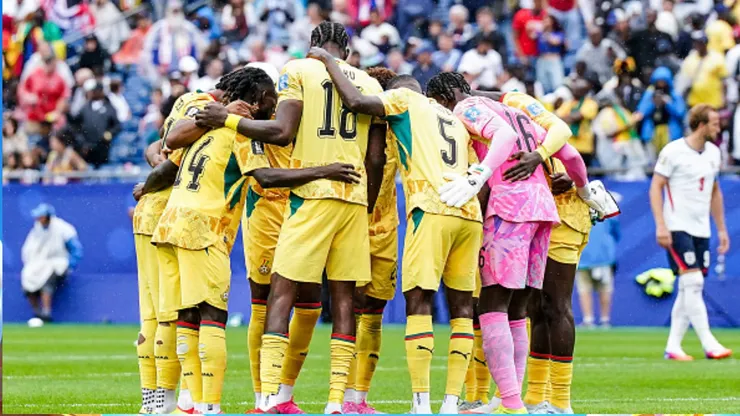 Jugadores de Ghana abrazados.