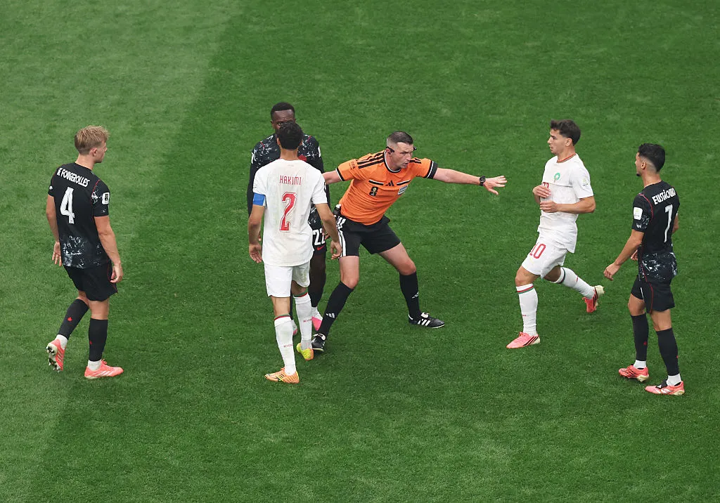 HOUSTON, TEXAS – JULY 04: Referee Michael Oliver separates Achraf Hakimi #2 of Morocco from Richie Laryea #22 of Canada during the FIFA World Cup 2026 Round of 16 match between Canada and Morocco at Houston Stadium on July 04, 2026 in Houston, Texas. (Photo by Lars Baron/Getty Images)