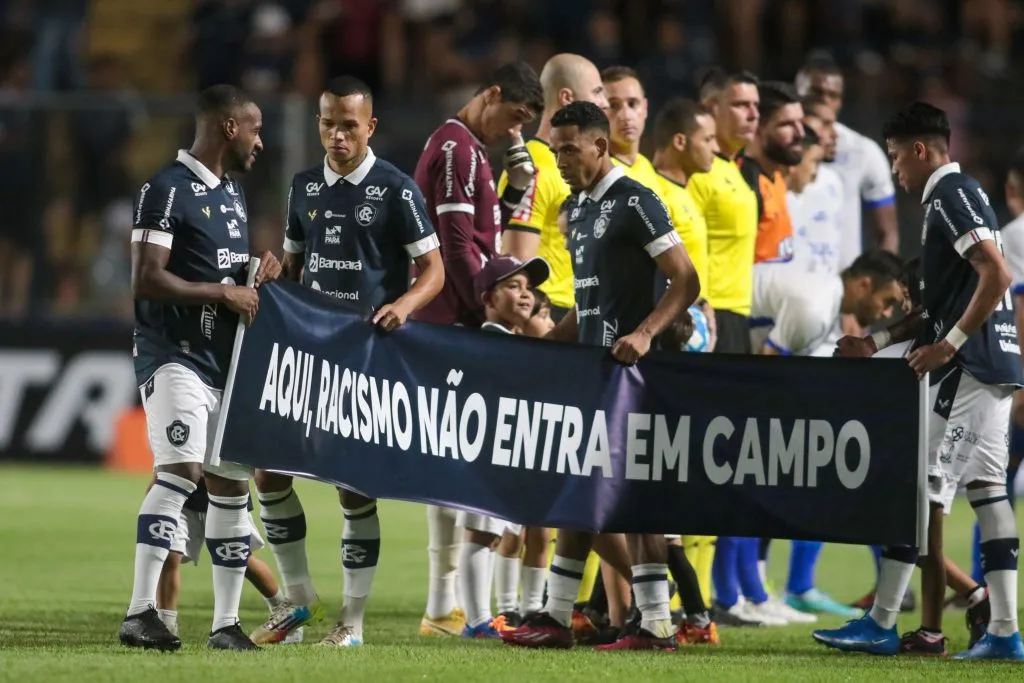 Foto: Fernando Torres/AGIF – Jogadores posam para fotos com faixa e a inscrição: “Aqui, racismo não entra em campo”, em manifestacao contra o racismo antes da partida entre Remo e Confianca no estadio Baenao pelo campeonato Brasileiro C 2023.