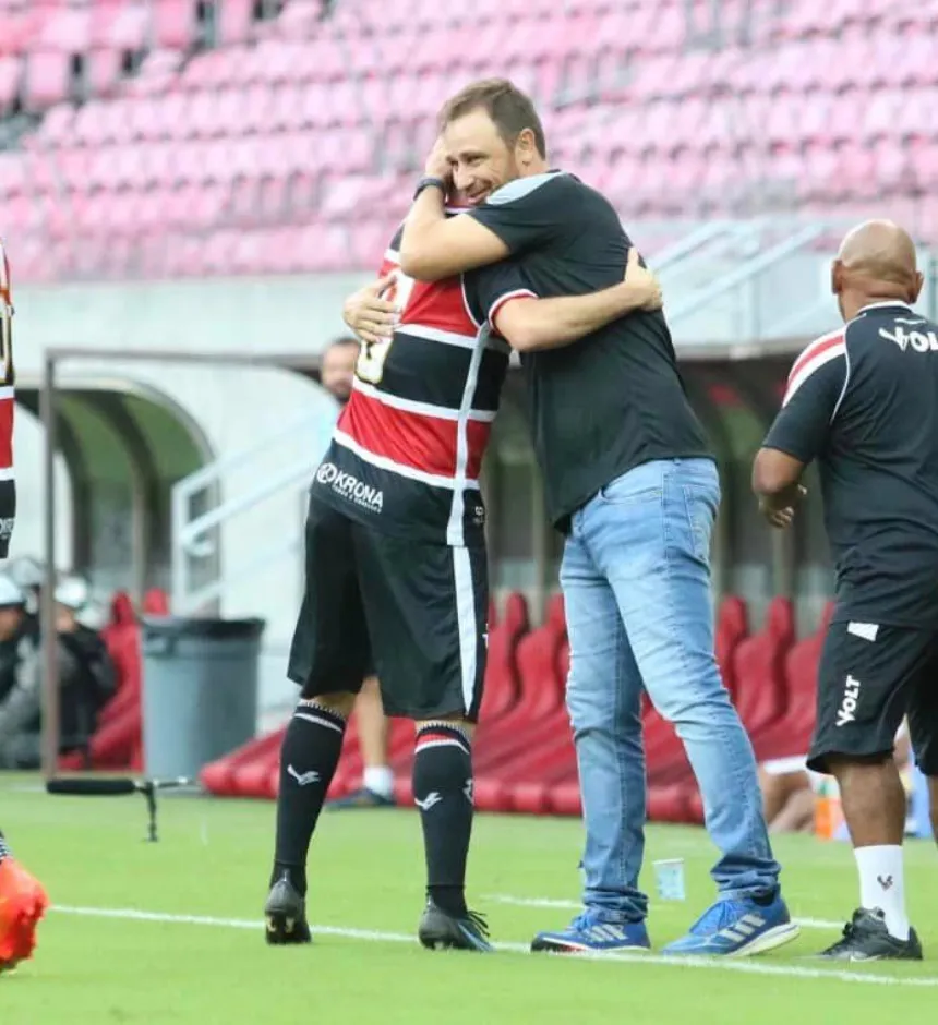 Foto: Reprodução Redes Sociais do Santa Cruz – Jogador Pipico abraça o técnico, Felipe Conceição, após marcar três gols em partida contra o Petrolina