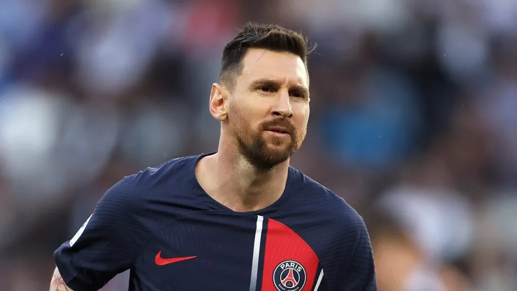 Messi aparece com o novo uniforme do PSG, predominantemente azul marinho, com uma faixa fina cinza e detalhes em vermelho
