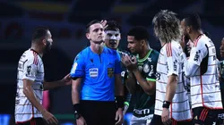 Imagem do árbitro sendo questionado em campo.