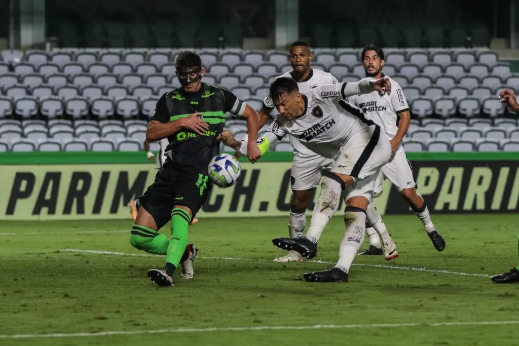 Kusevic, jogador do Coritiba, disputa lance com jogador do Botafogo durante partida no estádio Couto Pereira pelo campeonato Brasileiro A 2023. Foto: Robson Mafra/AGIF