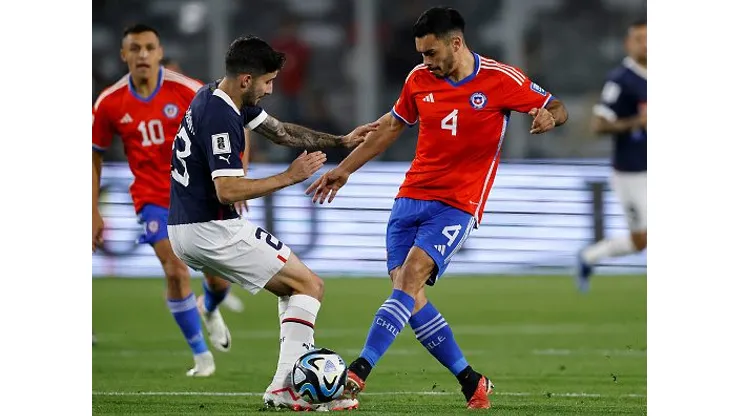 Villasanti disputando jogada com o jogador chileno em jogo pelas Eliminatórias. Foto: Marcelo Hernandez/Getty Images.