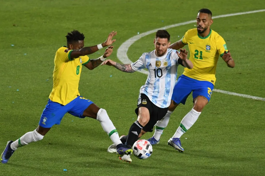 Messi jogador do Argentina disputa lance com Fred e Matheus Cunha jogadores do Brasil durante partida no estádio San Juan del Bicentenario pelo campeonato Eliminatórias Copa do Mundo 2022. Foto: FotoBaires/AGIF