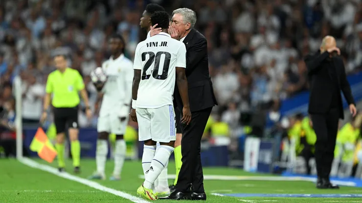 Carlo Ancelotti conversando com Vonicius Jr. durante partida. Foto: David Ramos/Getty Images