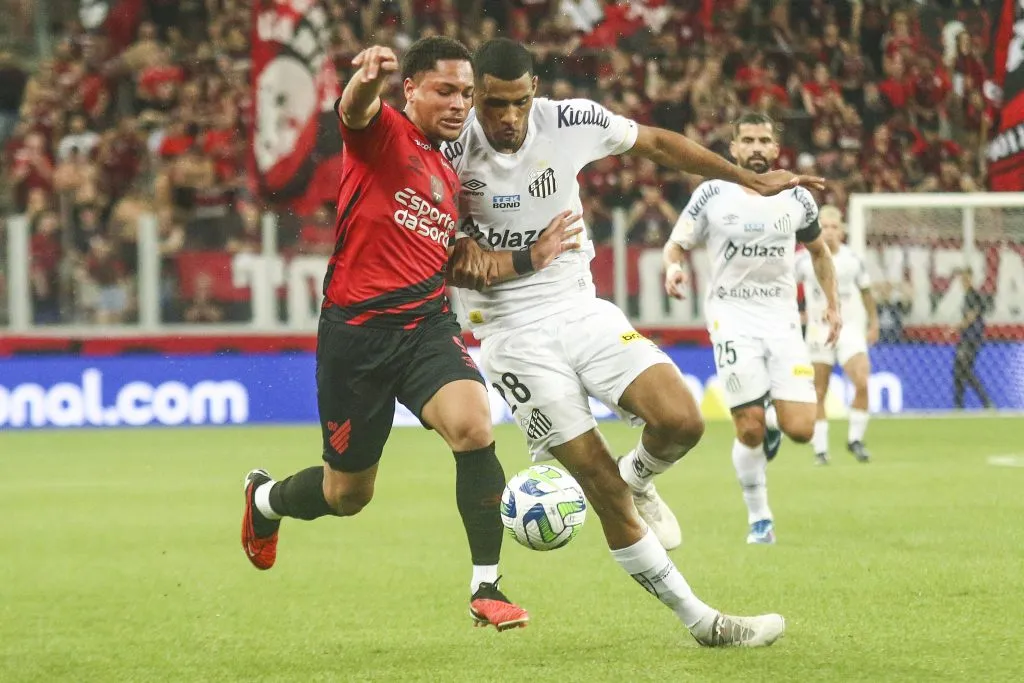 Vitor Roque, jogador do Athletico-PR, disputa lance com Joaquim, jogador do Santos, durante partida na Arena da Baixada pelo Campeonato Brasileiro – Foto: Gabriel Machado/AGIF