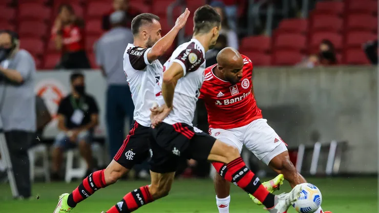 Patrick, jogador do Internacional, disputa lance com Everton Ribeiro e Rodrigo Caio, jogadores do Flamengo, durante partida no estádio Beira-Rio pelo Campeonato Brasileiro - Foto: Pedro H. Tesch/AGIF