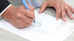 Foto: Pixabay - Uma pessoa assinando um documento.