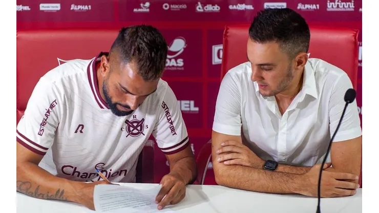 Foto: (Twitter Oficial CRB/@CRBoficial/@franciscocedrimfotografia) - Maicon, ao lado de Thiago Paes, assina contrato com o CRB