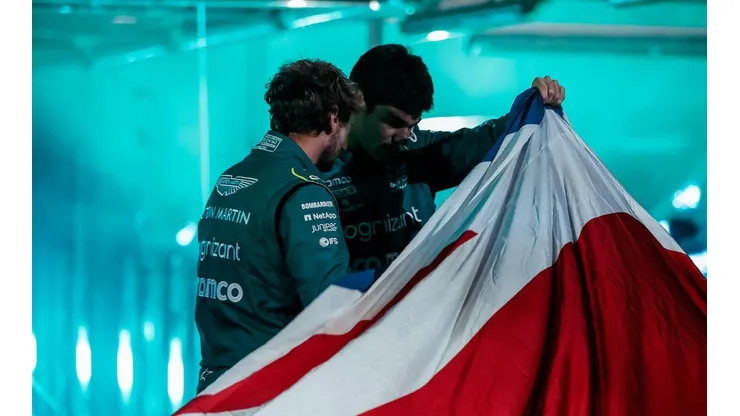 Foto oficial Aston Martin - Vettel e Stroll olhando o carro por baixo da bandeira da Grã-Bretanha