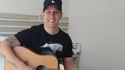 Foto: Arquivo pessoal - Jackson Follmann tocando violão. Ex-jogador virou músico e palestrante