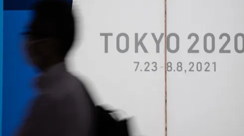 Um homem usando máscara caminha em frente a display dos Jogos Olímpicos de Tóquio 2020 (Foto: Getty Images)