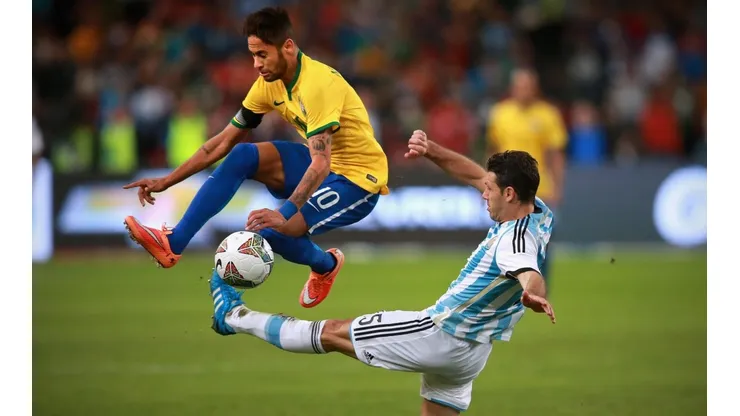 Neymar escapa de carrinho de Martin Demichelis, durante Superclássico das Américas de 2014 (Foto: Getty Images)