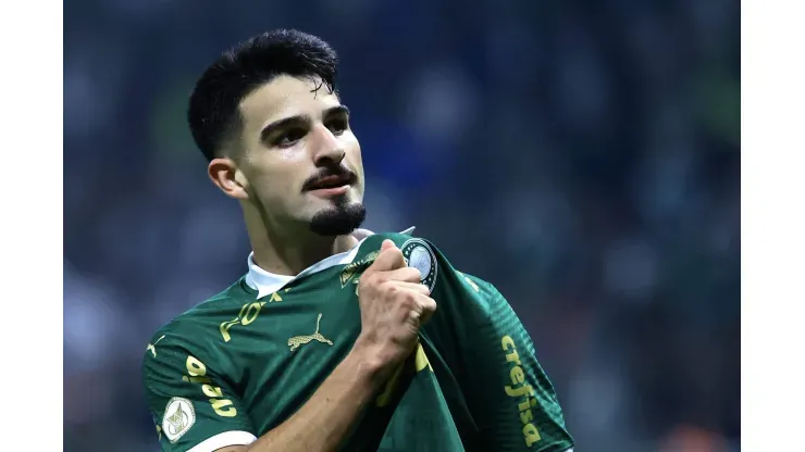 Flaco Lopez equipado de verde pelo Palmeiras, agarra emblema do clube na camiseta