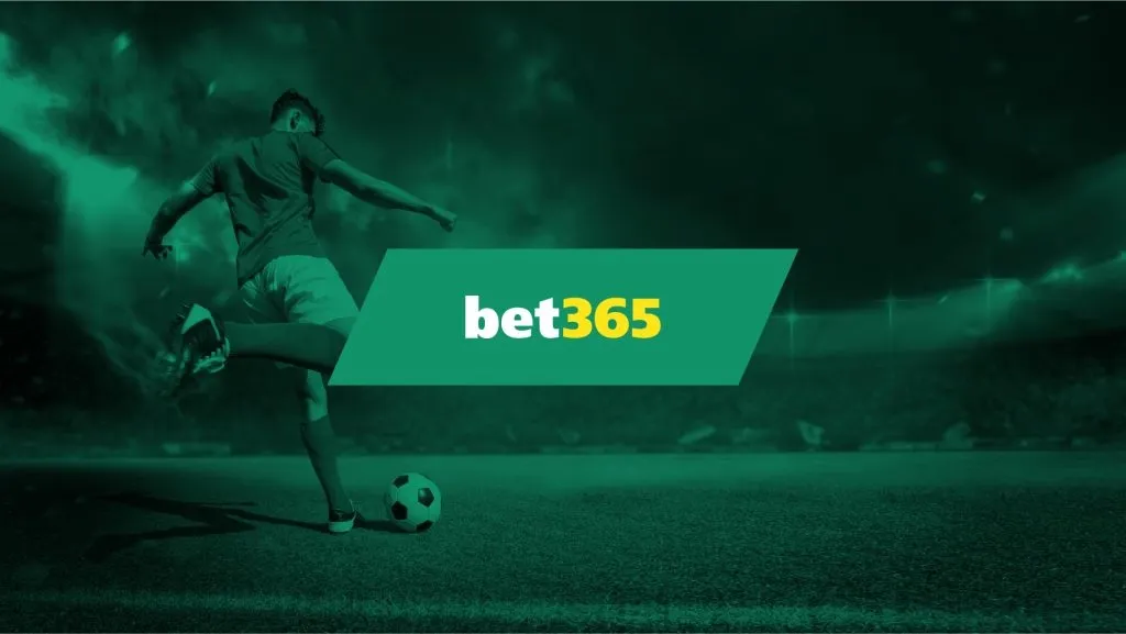 Imagem de divulgação da bet365 com o logo, em tons de branco e amarelo, contra fundo em tons sépia. No fundo, a imagem de jogador prestes a chutar uma bola em estádio. 