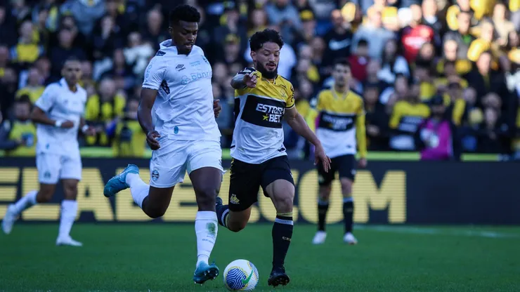 Arthur Caike jogador do Criciúma disputa lance com Jemerson jogador do Grêmio durante partida no Estádio Heriberto Hulse pelo Campeonato Brasileiro 2024. Foto: Leonardo Hubbe/AGIF