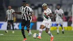 Jogador do Botafogo disputa lance com jogador do Fluminense durante partida. Foto: Thiago Ribeiro/AGIF