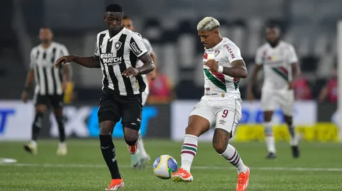 Jogador do Botafogo disputa lance com jogador do Fluminense durante partida. Foto: Thiago Ribeiro/AGIF