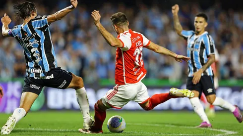CURITIBA, BRAZIL - JUNE 22: Lucas Alario of Internacional tries to shoot past Pedro Geromel (L) of Gremio during the match between Gremio and Internacional as part of Brasileirao 2024 at Couto Pereira Stadium on June 22, 2024 in Curitiba, Brazil. (Photo by Heuler Andrey/Getty Images)