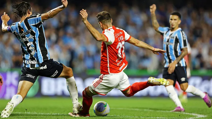 CURITIBA, BRAZIL - JUNE 22: Lucas Alario of Internacional tries to shoot past Pedro Geromel (L) of Gremio during the match between Gremio and Internacional as part of Brasileirao 2024 at Couto Pereira Stadium on June 22, 2024 in Curitiba, Brazil. (Photo by Heuler Andrey/Getty Images)