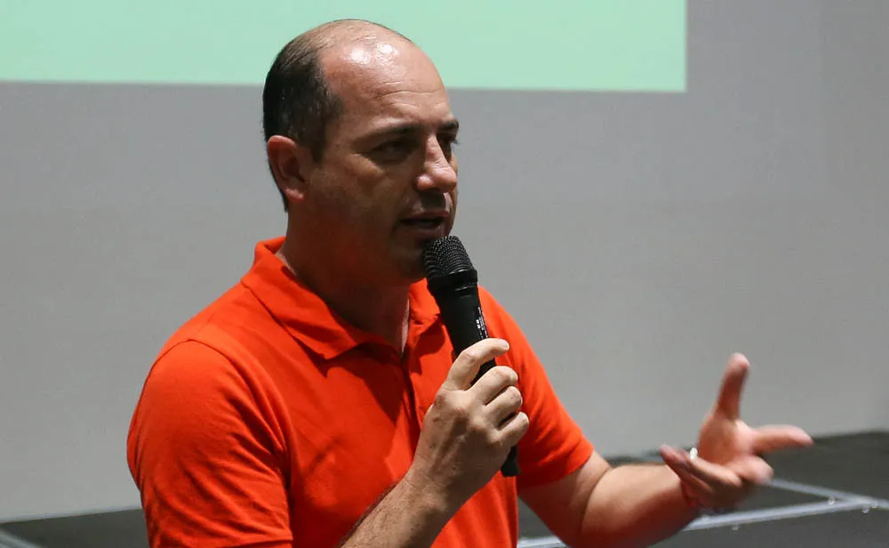 Cícero Souza falando no microfone com uniforme laranja - Foto: César Greco/Ag. Palmeiras