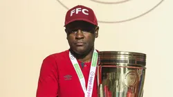 Visivelmente emocionado, PC Rodrigues, treinador das Meninas de Xerém, segura a taça da Copinha Feminina 2024 após a vitória sobre o Internacional no estádio do Canindé