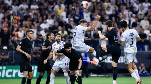 Jogador do Corinthians disputa lance com jogador do Santos durante partida no estádio Arena Corinthians pelo campeonato Paulista 2025.