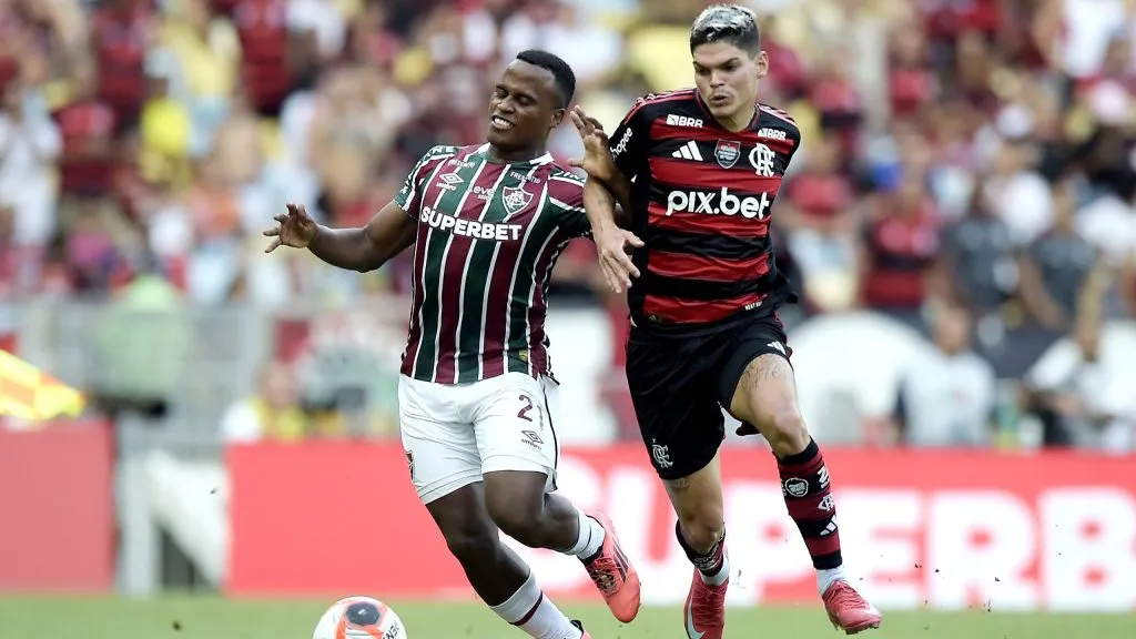Jhon Arias jogador do Fluminense disputa lance com Ayrton Lucas jogador do Flamengo durante partida no estádio Maracanã pelo campeonato Carioca 2025. Foto: Alexandre Loureiro/AGIF