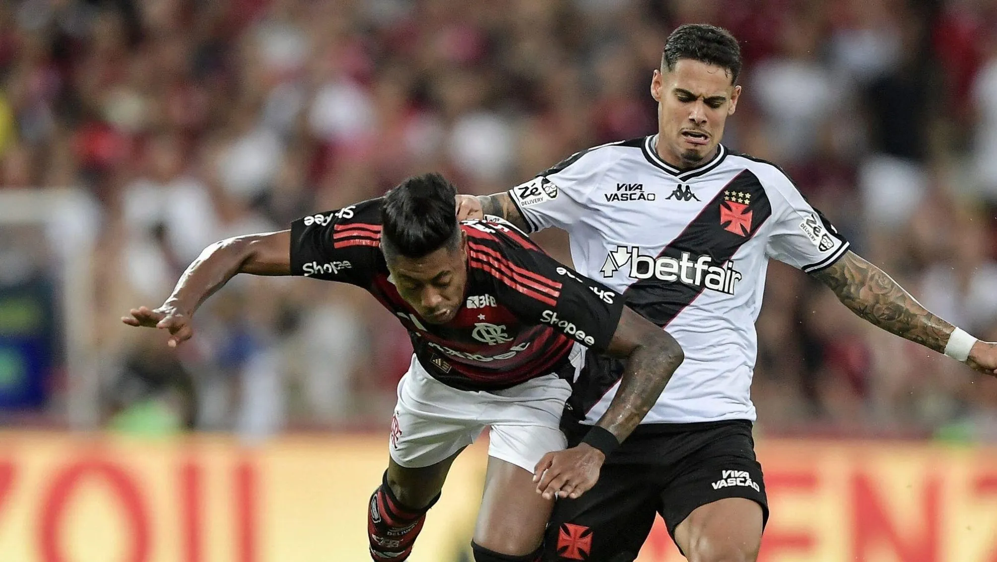 Lucas Freitas disputa bola com Bruno Henrique no Clássico dos Milhões. Foto: Thiago Ribeiro/AGIF (via AP)