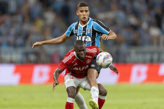 Gustavo Martins, jogador do Gremio, disputa lance com Valencia jogador do Internacional durante partida no estadio Arena do Gremio pelo campeonato Gaucho 2025. Foto: Liamara Polli/AGIF