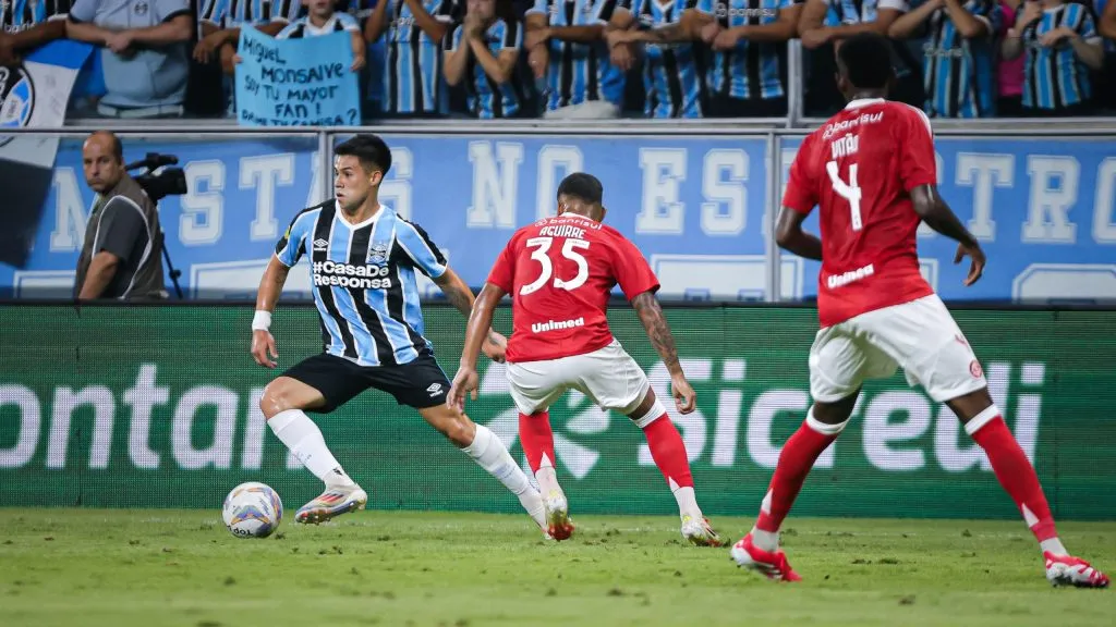 Atletas de Grêmio e Internacional disputam jogada, na Arena. Foto: Maxi Franzoi/AGIF.