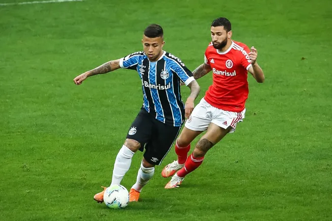 Matheus Henrique jogador do Grêmio disputa lance com Boschilia jogador do Internacional – Foto: Pedro H. Tesch/AGIF