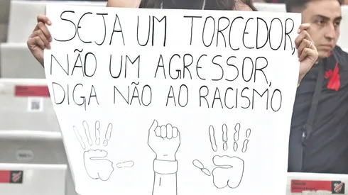 Cartaz: Seja um torcedor, não um agressor. Diga não ao racismo. Foto: Gabriel Machado/AGIF