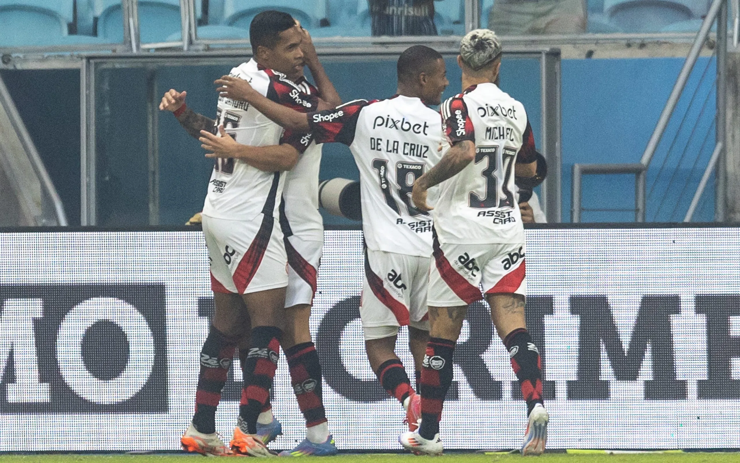 Alex Sandro comemora o gol Arrascaeta com os companheiro de elenco do Flamengo durante partida contra o Gremio na Arena. Foto: Liamara Polli/AGIF