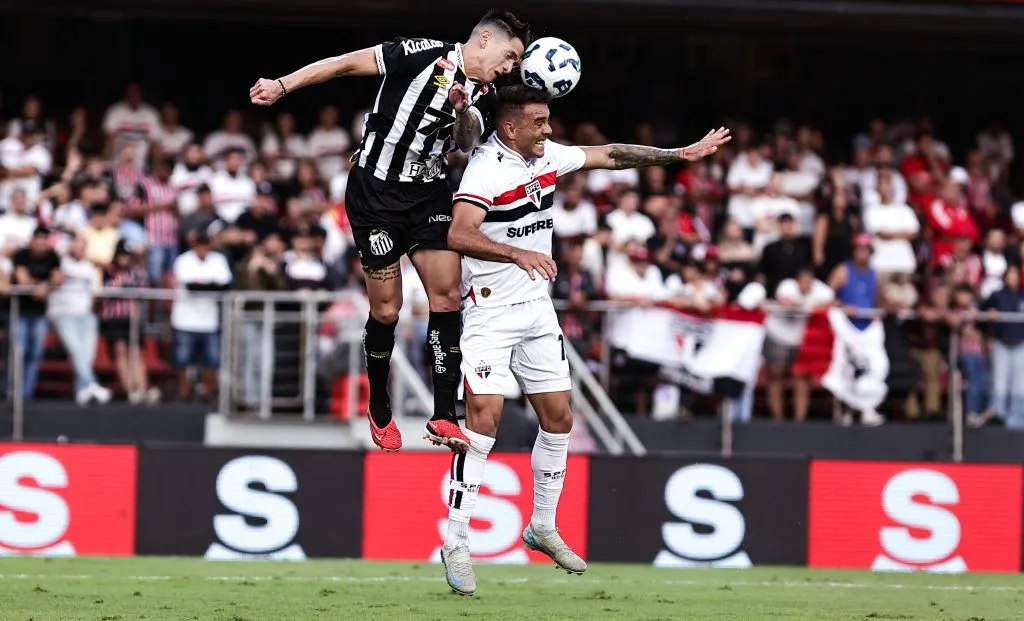 Jogador do Santos disputa lance com rival do São Paulo no clássico durante partida no estadio Morumbi pelo campeonato Brasileiro A 2025. Foto: Fabio Giannelli/AGIF