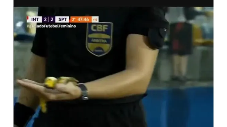 Quarta árbitra carrega pedaço de banana atirado pela torcida do Internacional no banco do Sport. Foto: Reprodução/TV Brasil