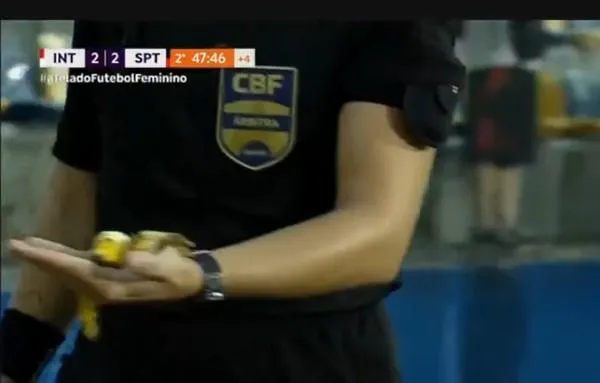 Quarta árbitra Andressa Hartmann carrega pedaço de banana atirado pela torcida do Internacional no banco do Sport. Foto: Reprodução/TV Brasil